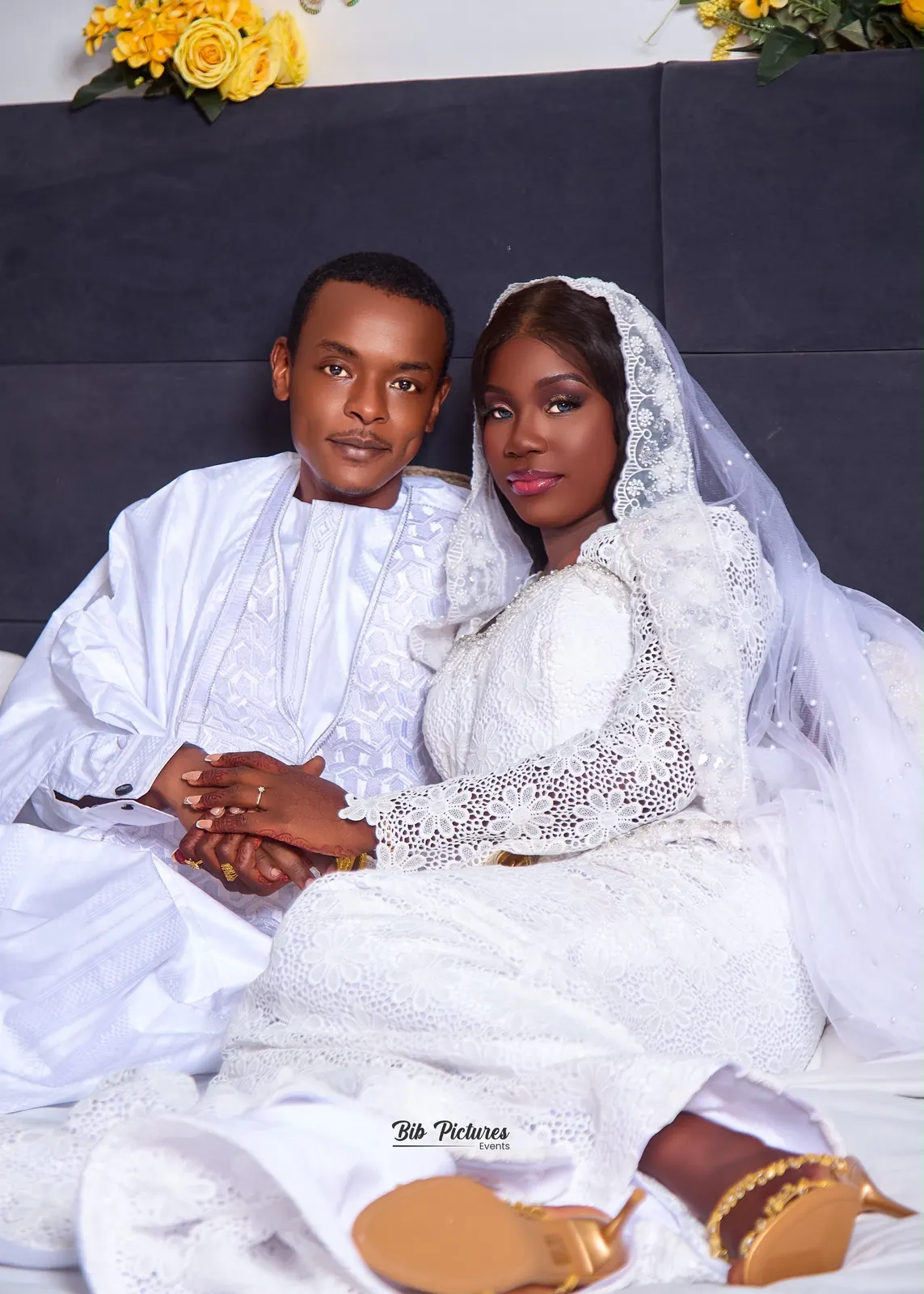 Mariage en blanc, couple assis, mains jointes.
